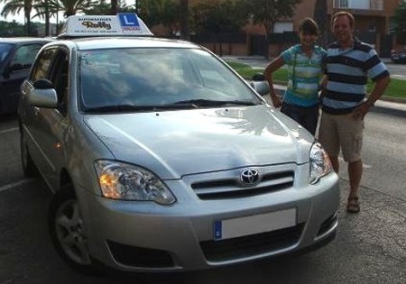 Clàudia Fornos y su padre, junto a un vehículo de la autoescuela