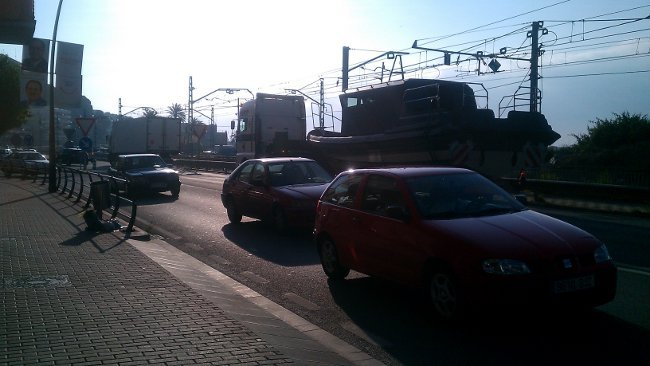El camión de la izquierda esperando, arrimado al arcén, impide el paso de un transporte especial