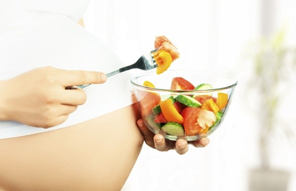healthy nutrition and pregnancy. pregnant woman's belly and vegetable salad
