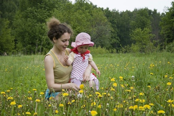 mother with baby on meadow