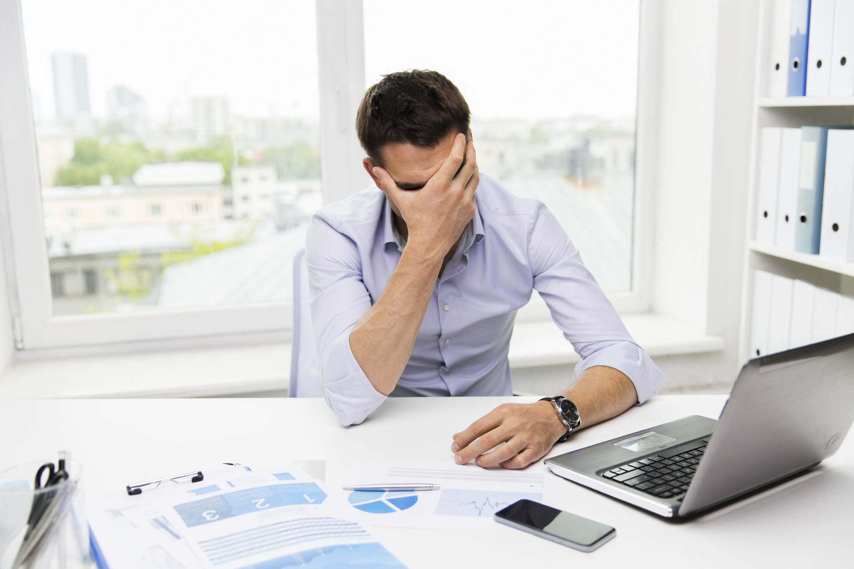businessman with laptop and papers in office