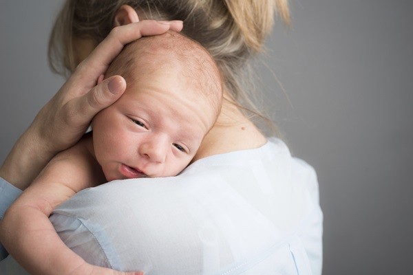 portrait of a newborn baby boy in his mother's shoulder