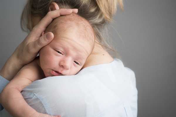 portrait of a newborn baby boy in his mother's shoulder