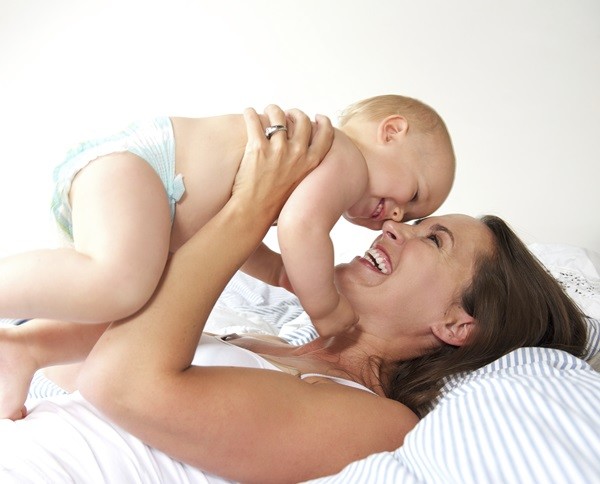 Close up portrait of a cheerful mother and cute baby playing
