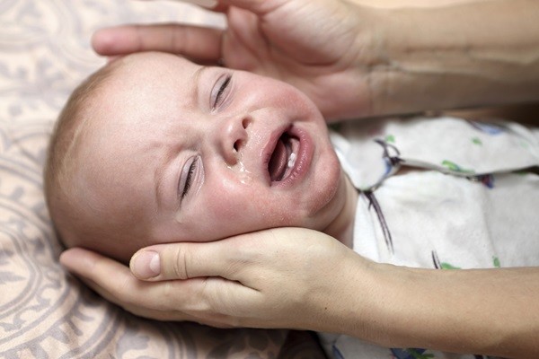 Crying child with a runny nose at home