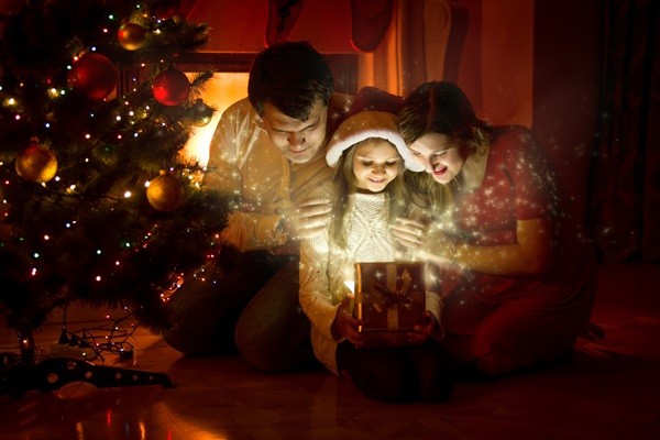 Happy family looking inside of magic Christmas gift box