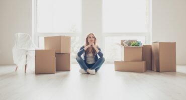 mujer sentada en su vivienda de alquiler
